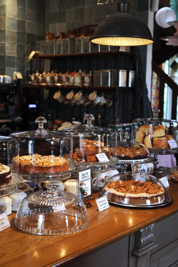Gâteaux maison présentés sous cloche au salon de thé Les Bonheurs d’Éléonore à Saint-Cast-le-Guildo, ambiance chaleureuse et artisanale.